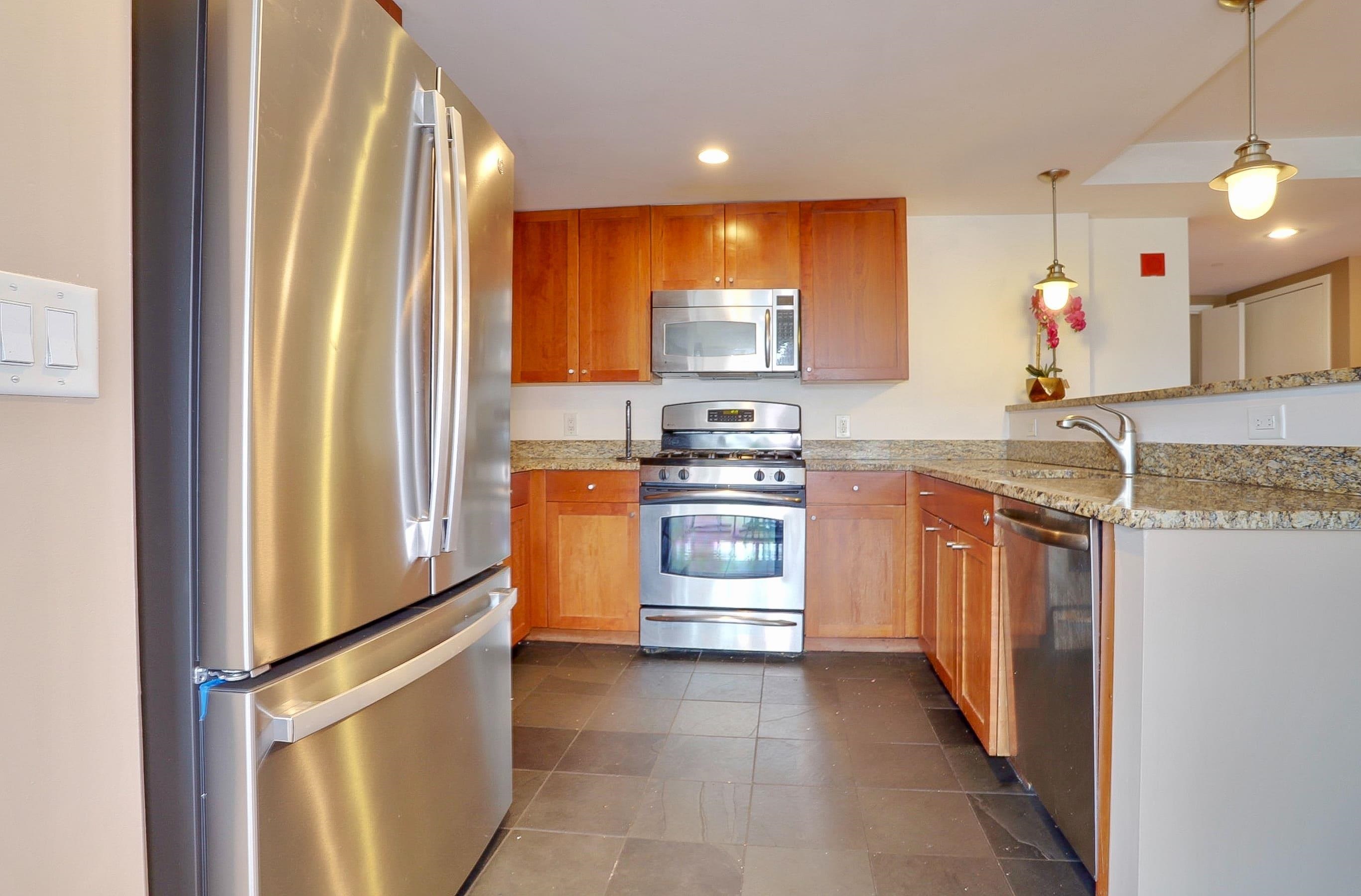 700 Grove Street, Unit 4F Jersey City, NJ 07310 - Photo 8 of 30 a kitchen with stainless steel appliances granite countertop a refrigerator and a stove