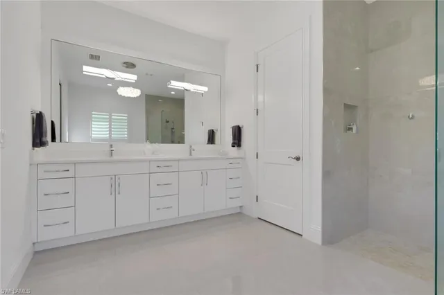 a spacious bathroom with a double vanity sink and a mirror