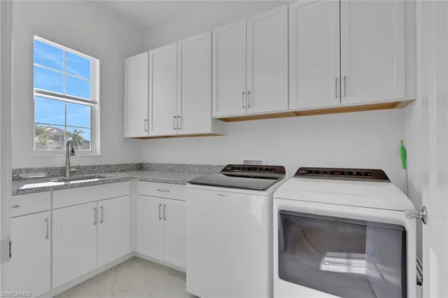 a kitchen with granite countertop white cabinets and sink