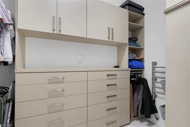 a view of walk in closet with clothes and shoes
