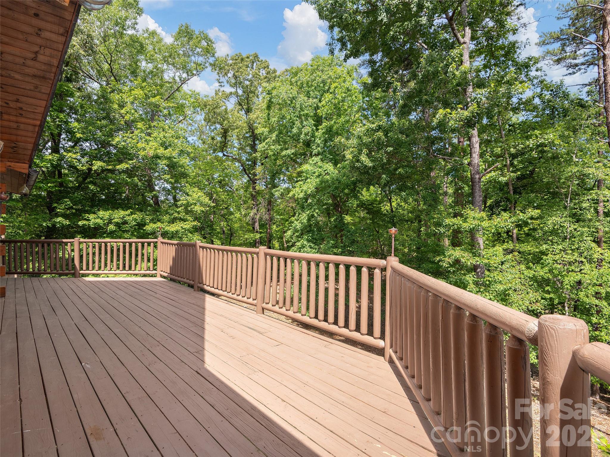 413 Green Hills Road Mill Spring, NC 28756 - Photo 39 of 48 a balcony with wooden floor and trees in the back
