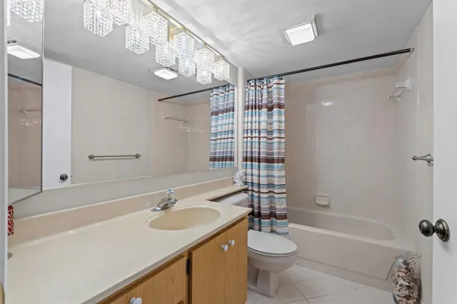 a bathroom with a sink a toilet a mirror a vanity and shower