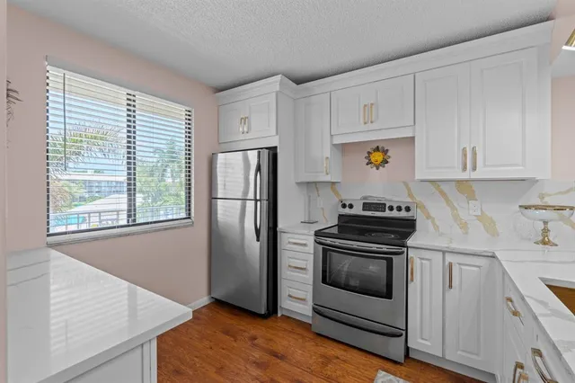 a kitchen with white cabinets and stainless steel appliances