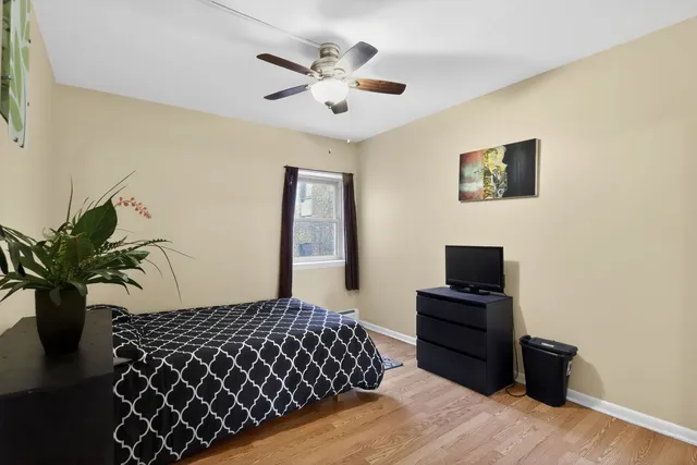 a bedroom with a bed and a potted plant