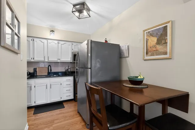 a kitchen with stainless steel appliances a sink cabinets and wooden floor