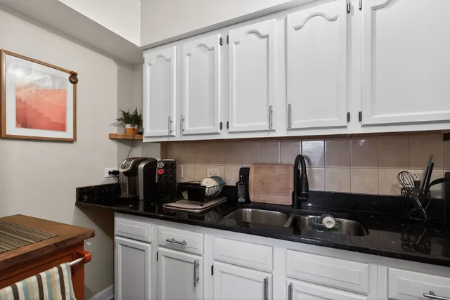 a kitchen with stainless steel appliances granite countertop white cabinets sink and dishwasher