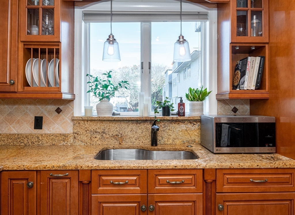 905 Sherwood Forest Lane, Unit 905 Saugus, MA 01906 - Photo 11 of 42 a kitchen with granite countertop a sink and a window