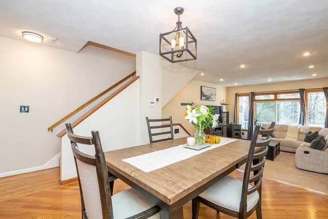 a dining room with furniture a chandelier and wooden floor