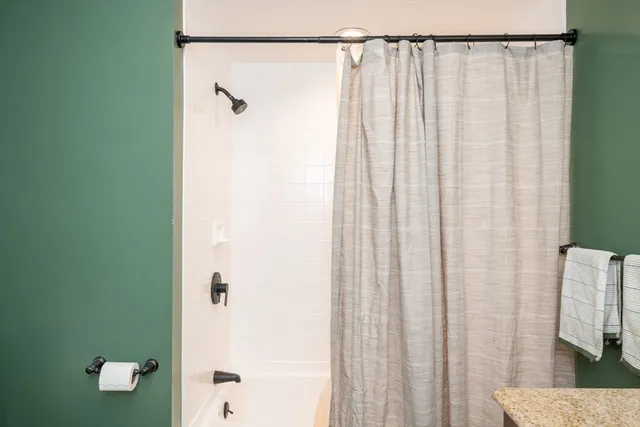 a bathroom with a shower curtain and a window