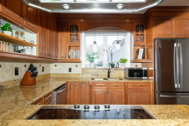 a kitchen with stainless steel appliances granite countertop a sink stove and cabinets