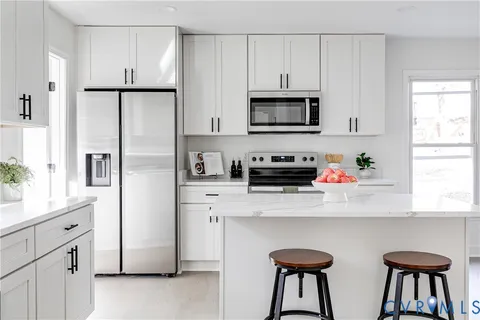 a kitchen with stainless steel appliances white cabinets and a refrigerator