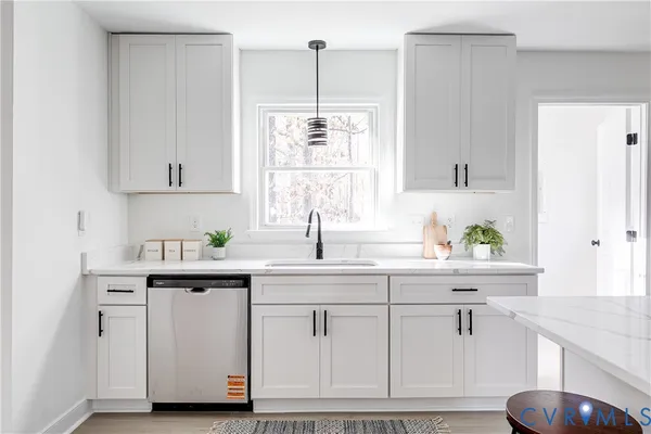 a kitchen with white cabinets and sink