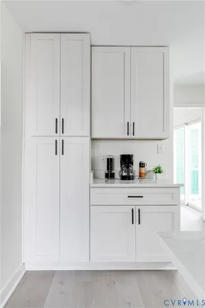 a kitchen with white cabinets and white appliances