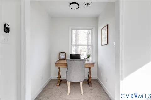 a view of a workspace with furniture and a window