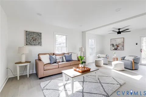 a living room with furniture a rug and a window