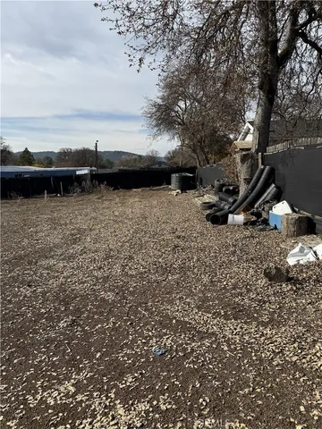 a view of swimming pool with lawn chairs and iron fence