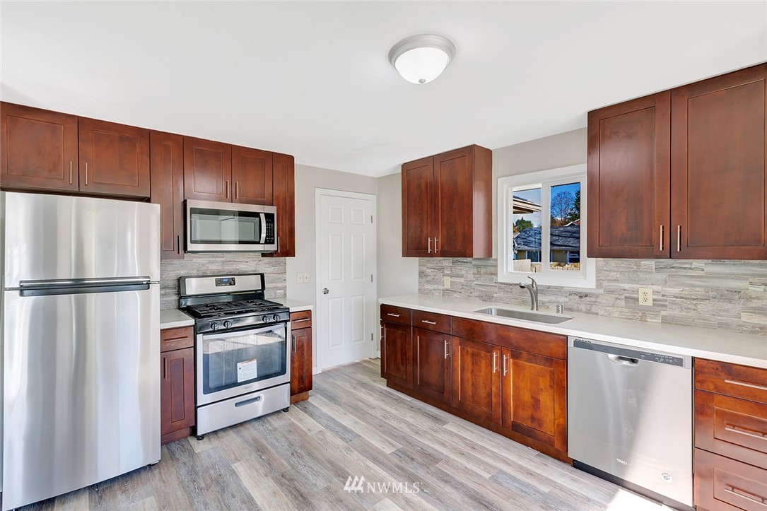 5300 Northeast 4th Street Renton, WA 98059 - Photo 4 of 12 a kitchen with stainless steel appliances granite countertop a stove refrigerator sink and microwave