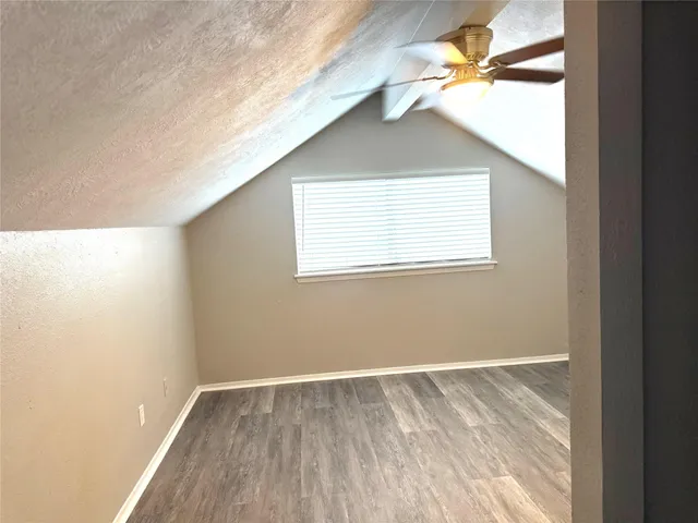 an empty room with a window and a ceiling fan