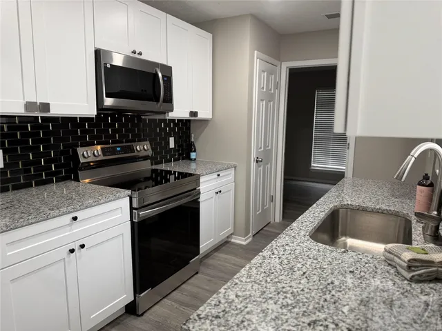 a kitchen with a sink stove and microwave