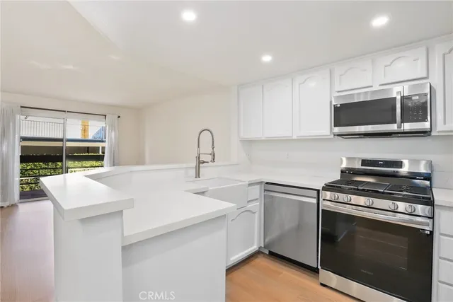 a kitchen with stainless steel appliances a stove microwave and sink