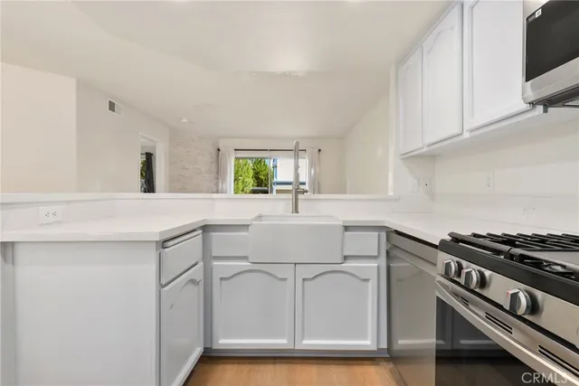 a kitchen with granite countertop a sink cabinets and appliances