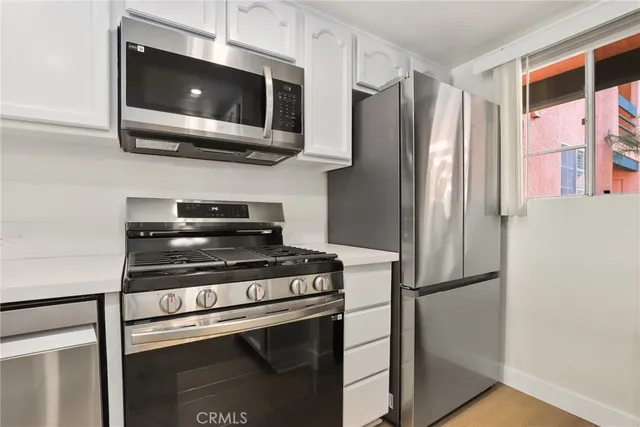 a kitchen with stainless steel appliances granite countertop a refrigerator microwave and sink