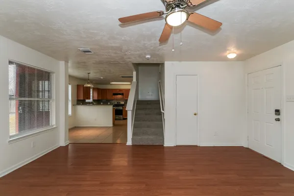 a view of empty room with wooden floor and ceiling fan