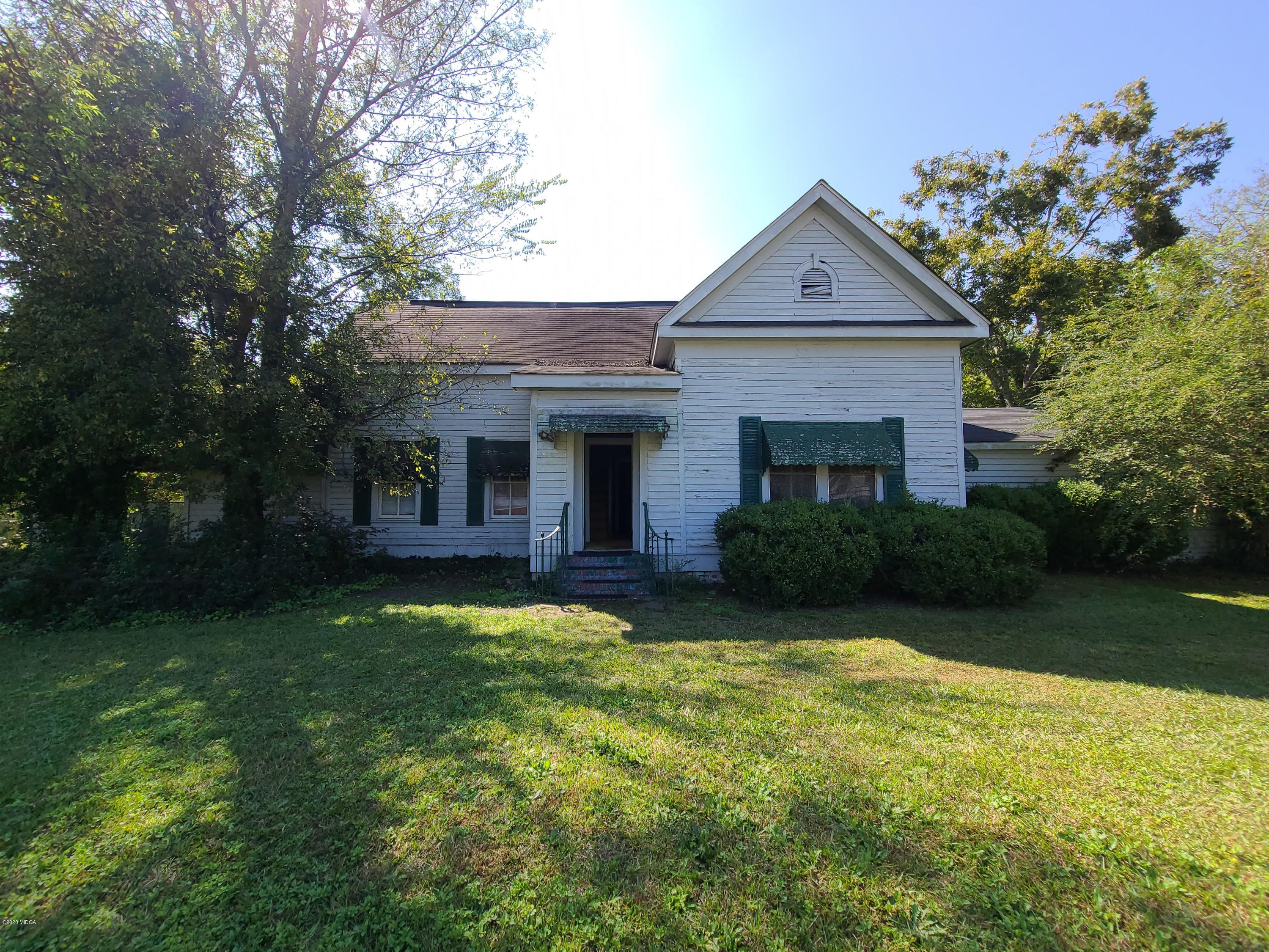 3824 Hartley Bridge Road Macon, GA 31216 - Photo 1 of 26 a front view of a house with a garden and trees