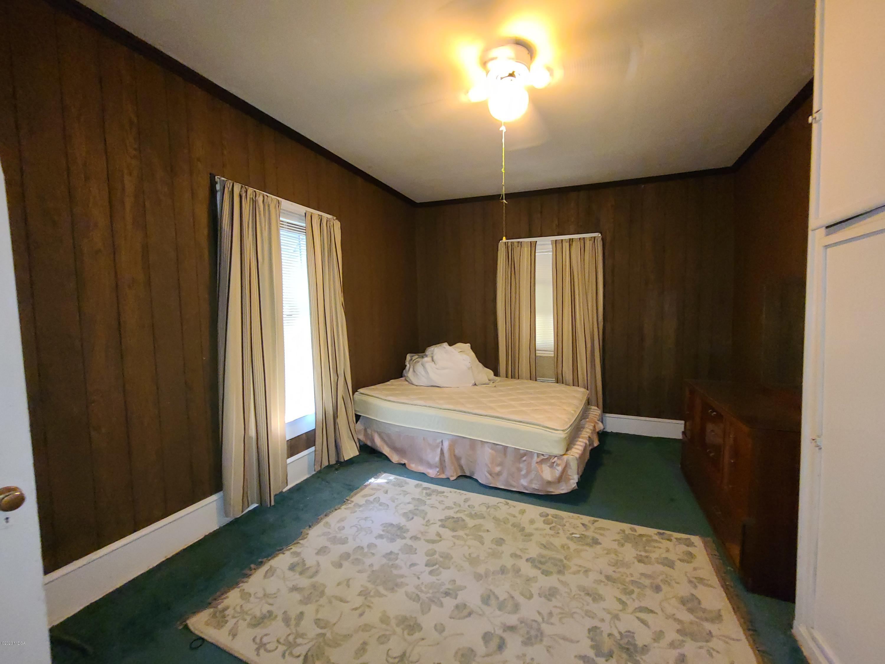 3824 Hartley Bridge Road Macon, GA 31216 - Photo 16 of 26 a spacious bedroom with a bed and a chandelier