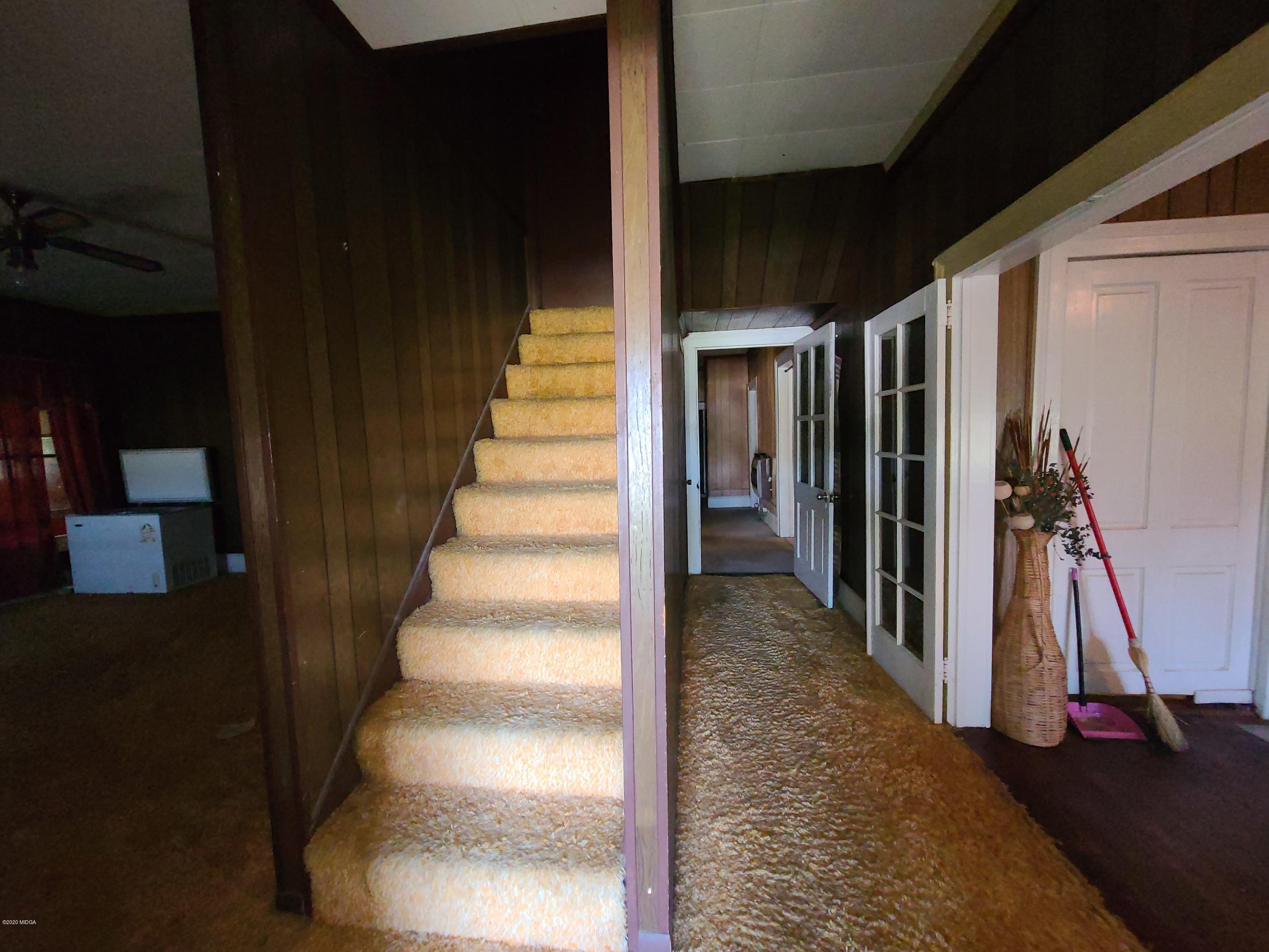 3824 Hartley Bridge Road Macon, GA 31216 - Photo 5 of 26 a view of a livingroom with a floor to ceiling window and stairs