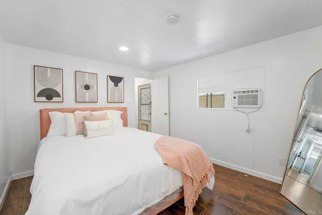 a bedroom with a large bed and a wooden floor