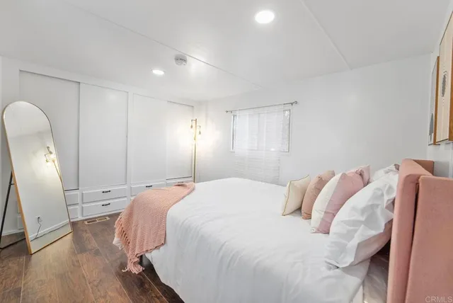 a spacious bedroom with a bed and a mirror