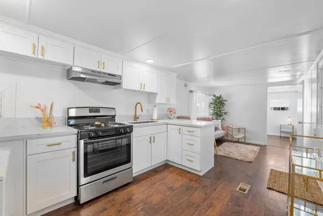 a kitchen with stainless steel appliances white cabinets and a stove top oven