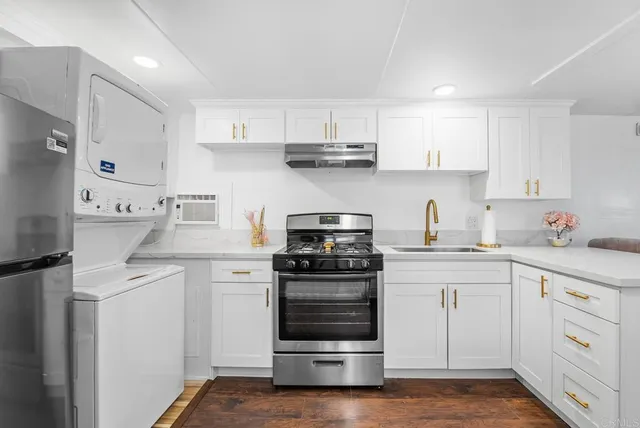 a kitchen with cabinets stainless steel appliances and wooden floor