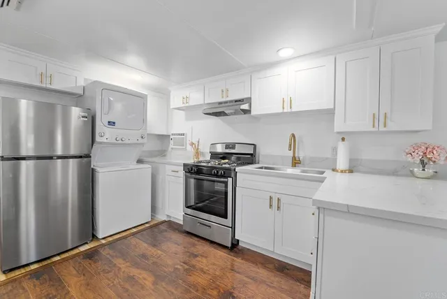 a kitchen with cabinets stainless steel appliances and sink