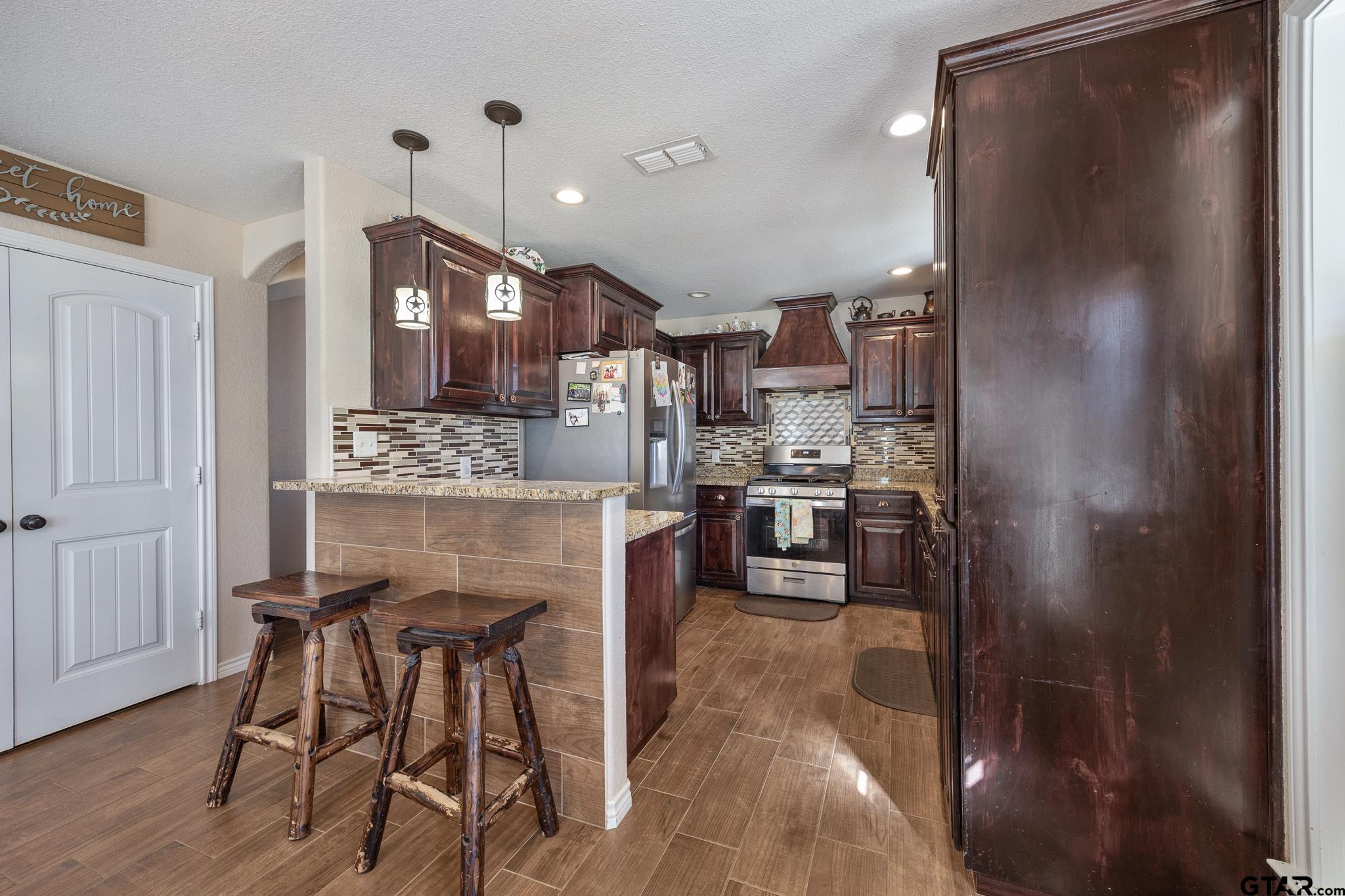 7573 County Road 48 Tyler, TX 75704 - Photo 12 of 31 a kitchen with kitchen island a counter top space a sink stainless steel appliances and cabinets