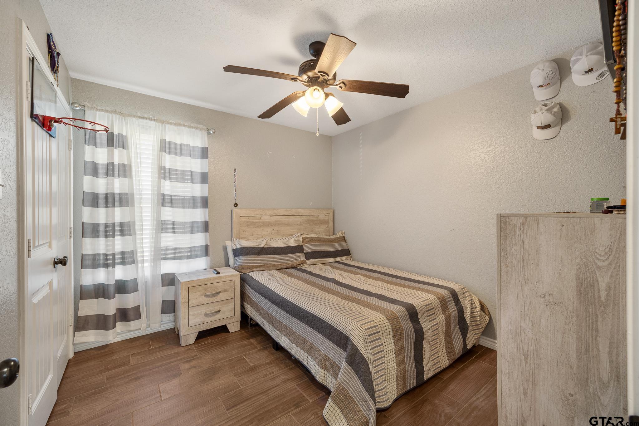 7573 County Road 48 Tyler, TX 75704 - Photo 22 of 31 a bedroom with a bed and a chandelier