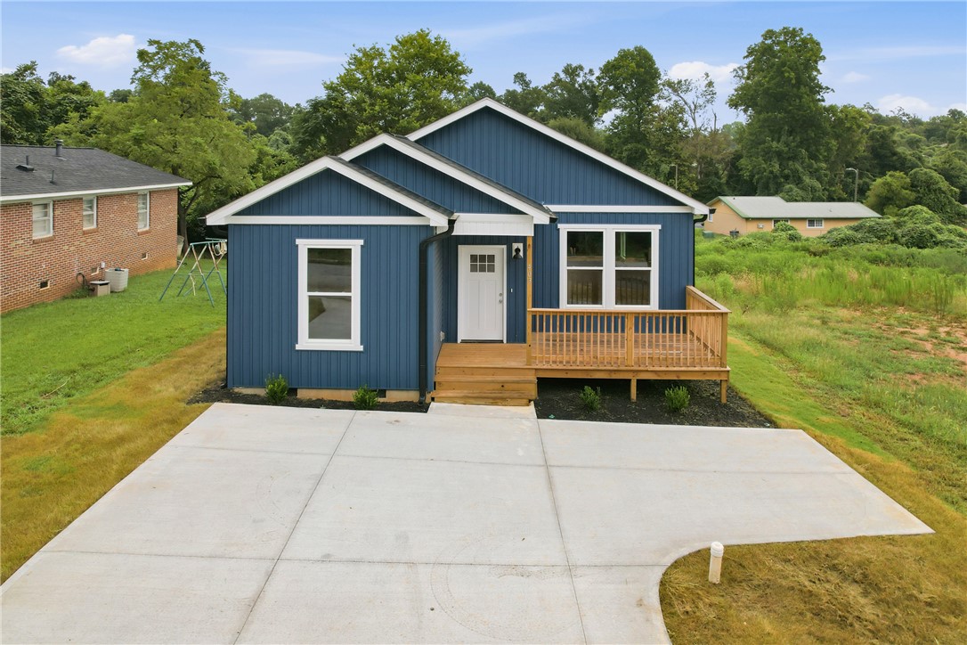 403 Tribble Street Seneca, SC 29678 - Photo 1 of 37 A deep blue facade with white trim frames a welcoming porch and a broad concrete driveway.