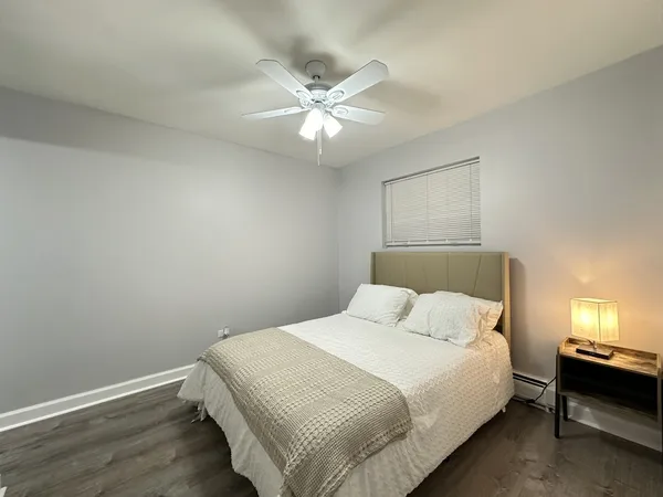 a bedroom with a bed and a ceiling fan