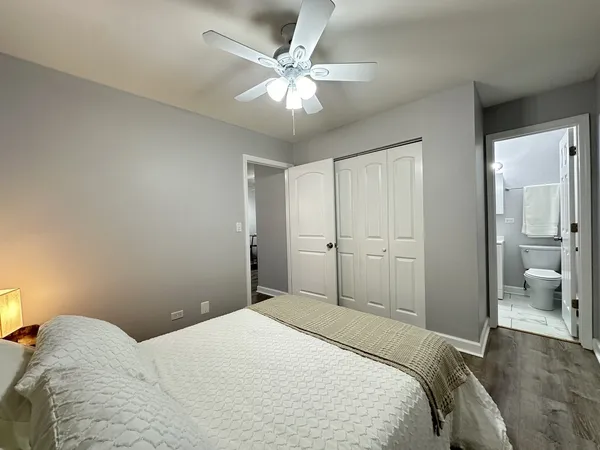 a bedroom with a large bed and a chandelier