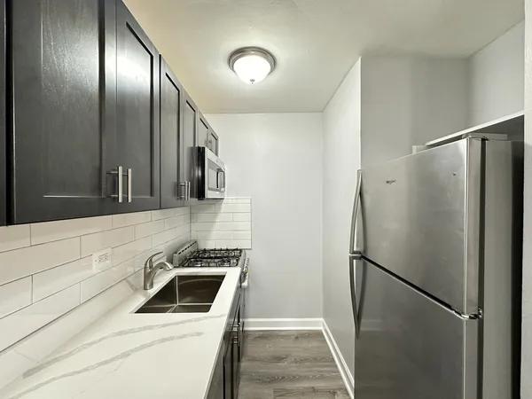 a kitchen with a refrigerator and a sink