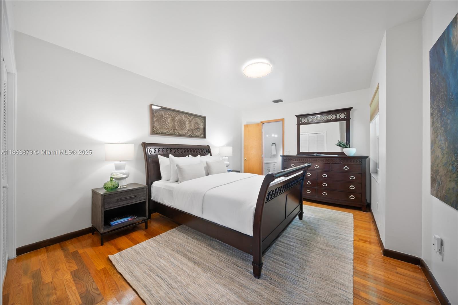 6125 Southwest 109th Street Pinecrest, FL 33156 - Photo 25 of 40 a bedroom with a bed and wooden floor