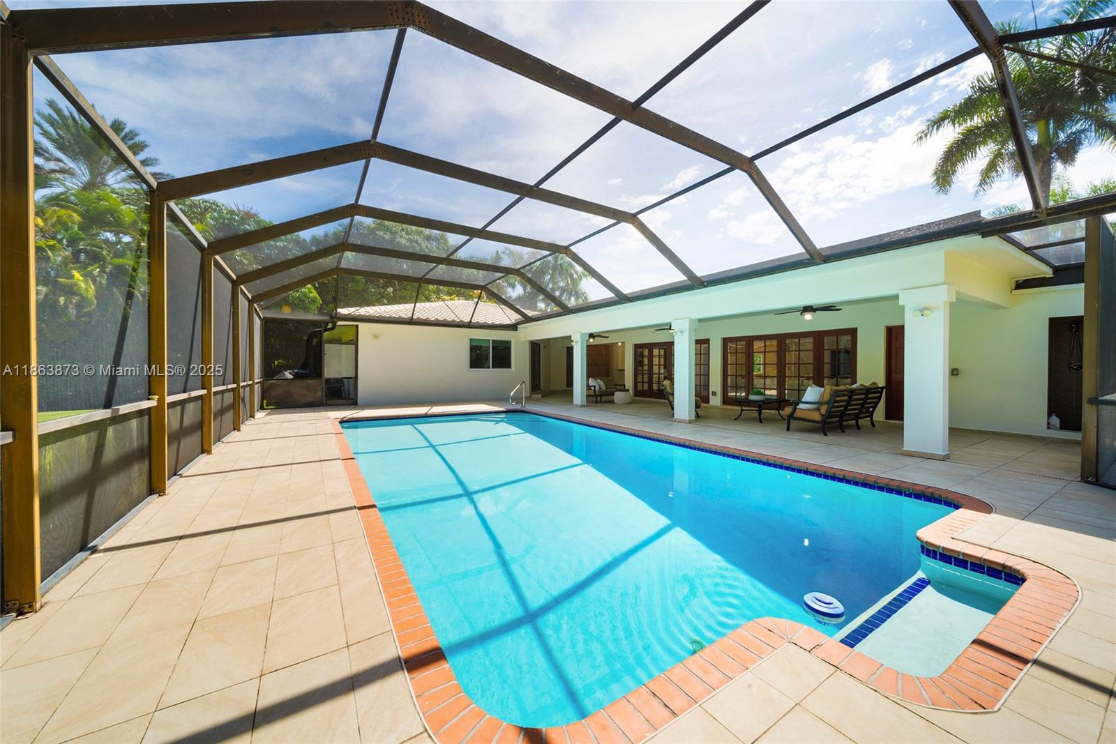 6125 Southwest 109th Street Pinecrest, FL 33156 - Photo 34 of 40 a view of a patio with table and chairs under an umbrella