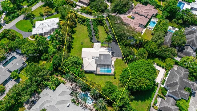 an aerial view of a house with a yard and lake view