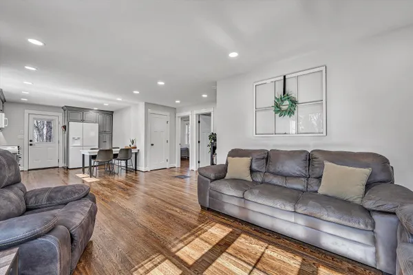 a living room with furniture and a dining table with kitchen view