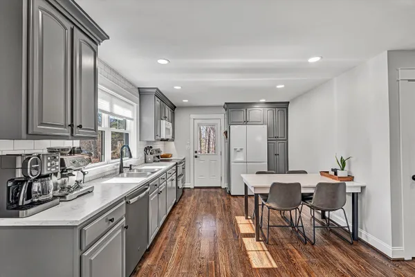 a kitchen with stainless steel appliances a sink stove and wooden floor