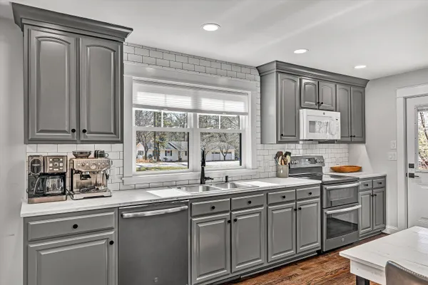 a kitchen with stainless steel appliances granite countertop a sink a stove and cabinets