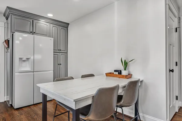 a white kitchen with a refrigerator and table