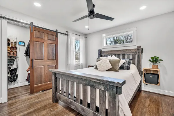 a bedroom with a bed a window and potted plant