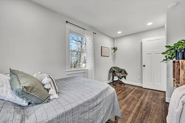 a bedroom with a bed and wooden floor